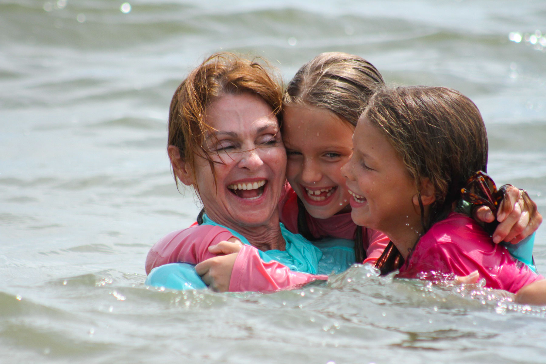 Grandmother and granddaughters enjoy a swim in the ocean