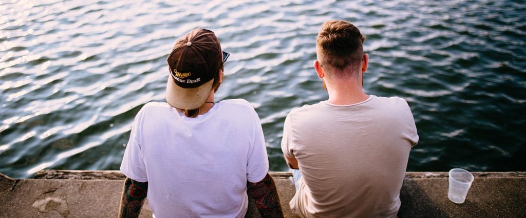 Men sitting, talking on dock
