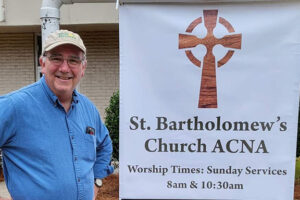 Bill Oldland with St. Bart's sign