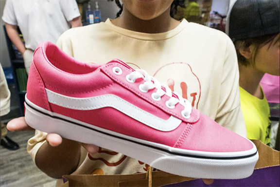 Girl holding donated shoe