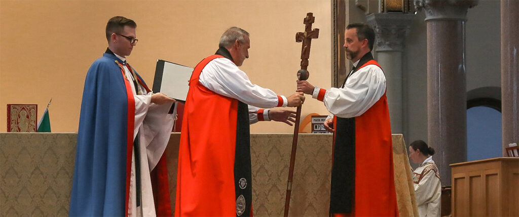 Archbishop Steve Wood receives cross from Archbishop Foley Beach